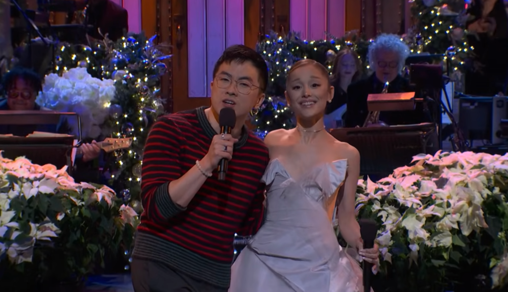 Bowen Yang and Arianna Grande sing during 